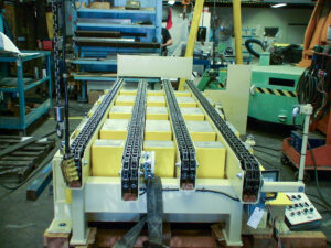 Yellow industrial conveyor system with chains in a workshop