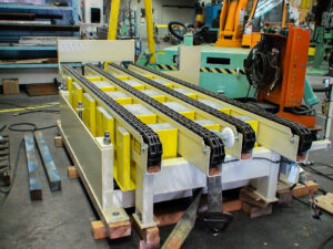 A yellow industrial conveyor system in a factory setting.