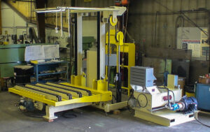 Large industrial machine with yellow components, likely used for material processing in a workshop.