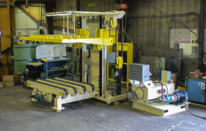 Large industrial machine with a yellow lift mechanism in a workshop