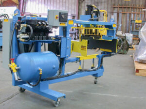 Blue and yellow industrial machine on wheels with a large cylinder