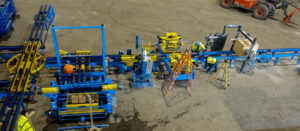 Workers operating an industrial assembly line with blue and yellow machinery in a factory setting.